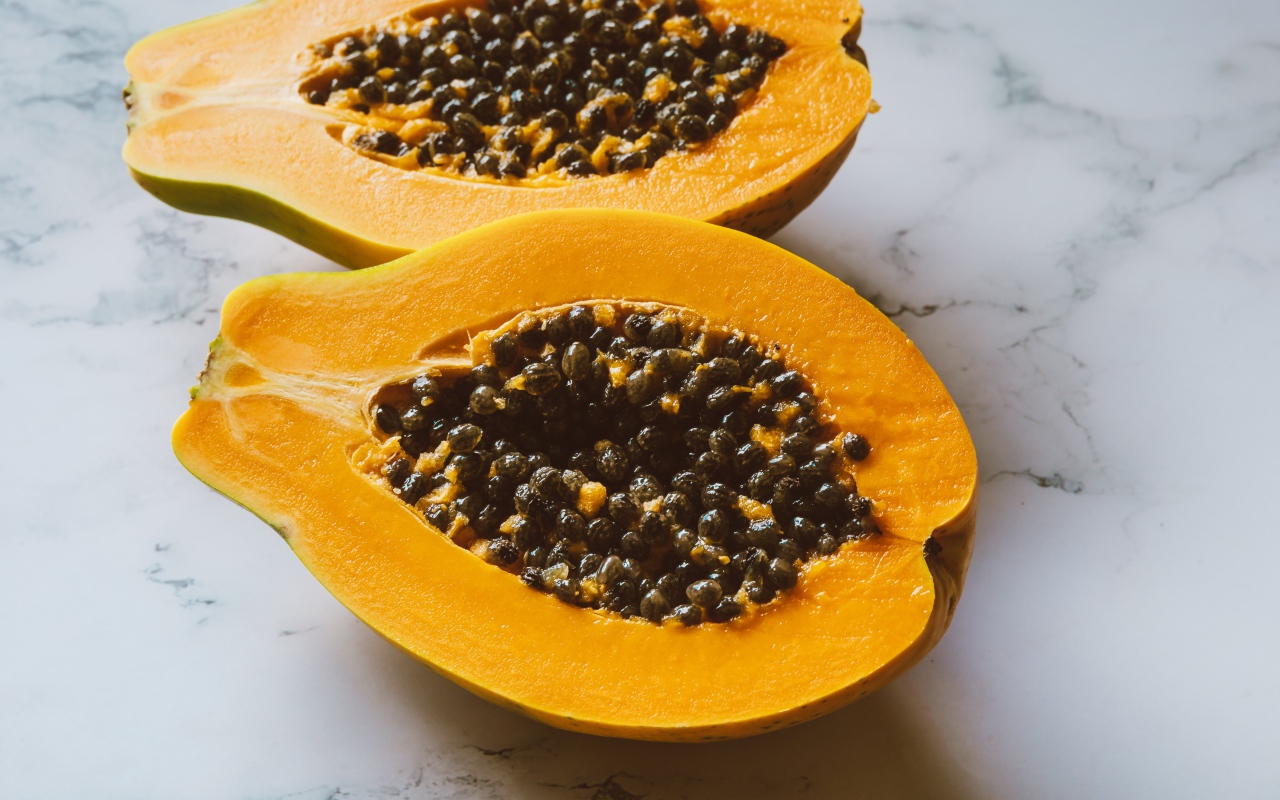 Разрезанный плод папайи на столе 