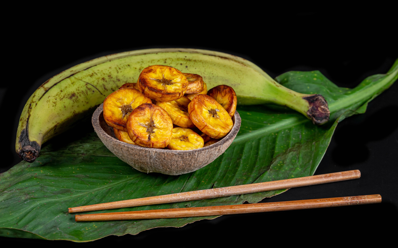 Сушеные бананы на столе с палочками и зеленым листом