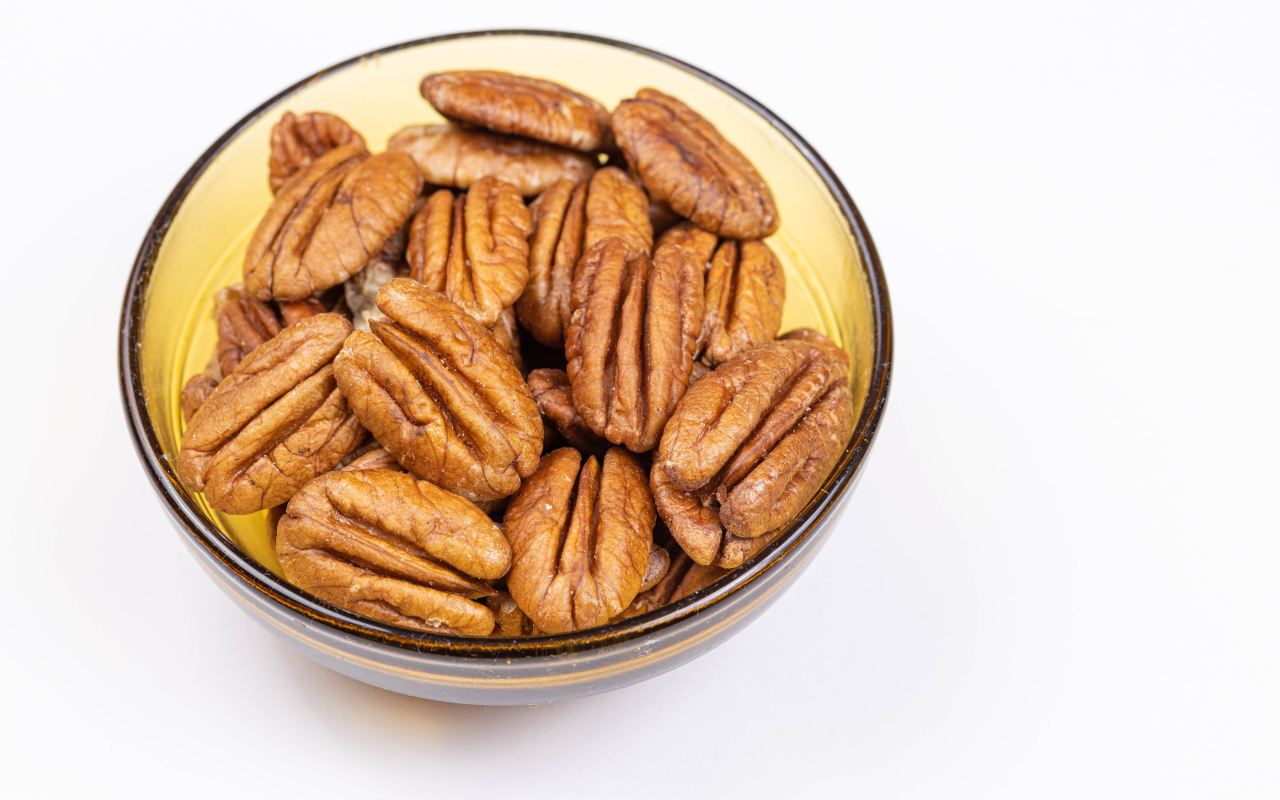 Ядра орехов в миске на белом фоне