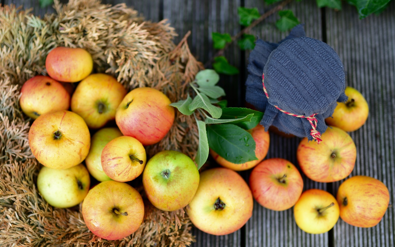 Много спелых яблок на столе с вареньем 