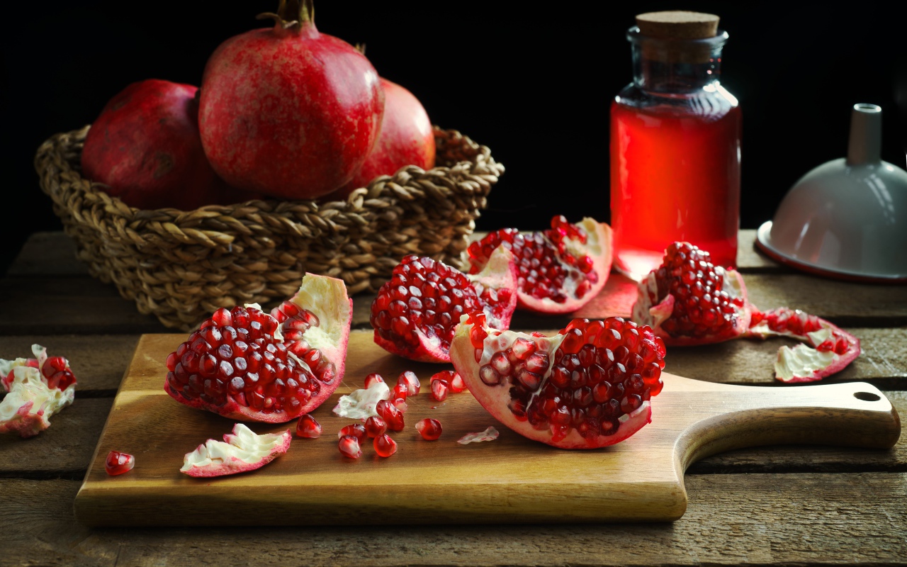 Плоды граната на столе с соком 