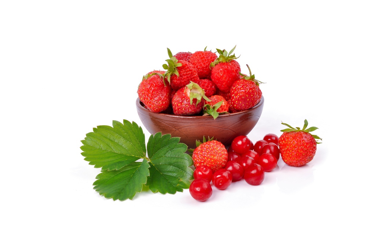 Red strawberry on white plate with berries of chinese cherry