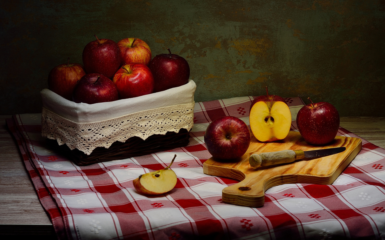 Спелые красные яблоки на столе с ножом