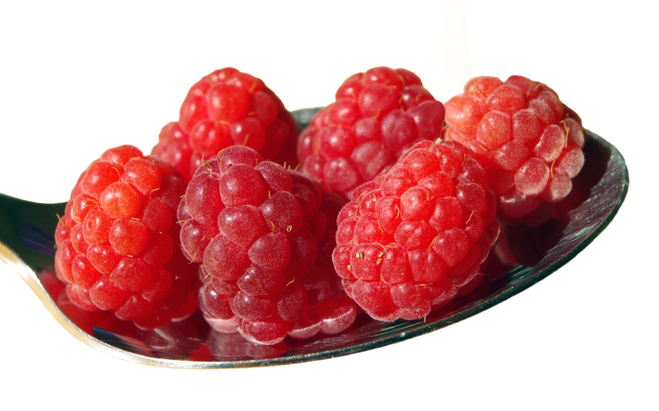 Спелая красная малина в ложке на белом фоне 