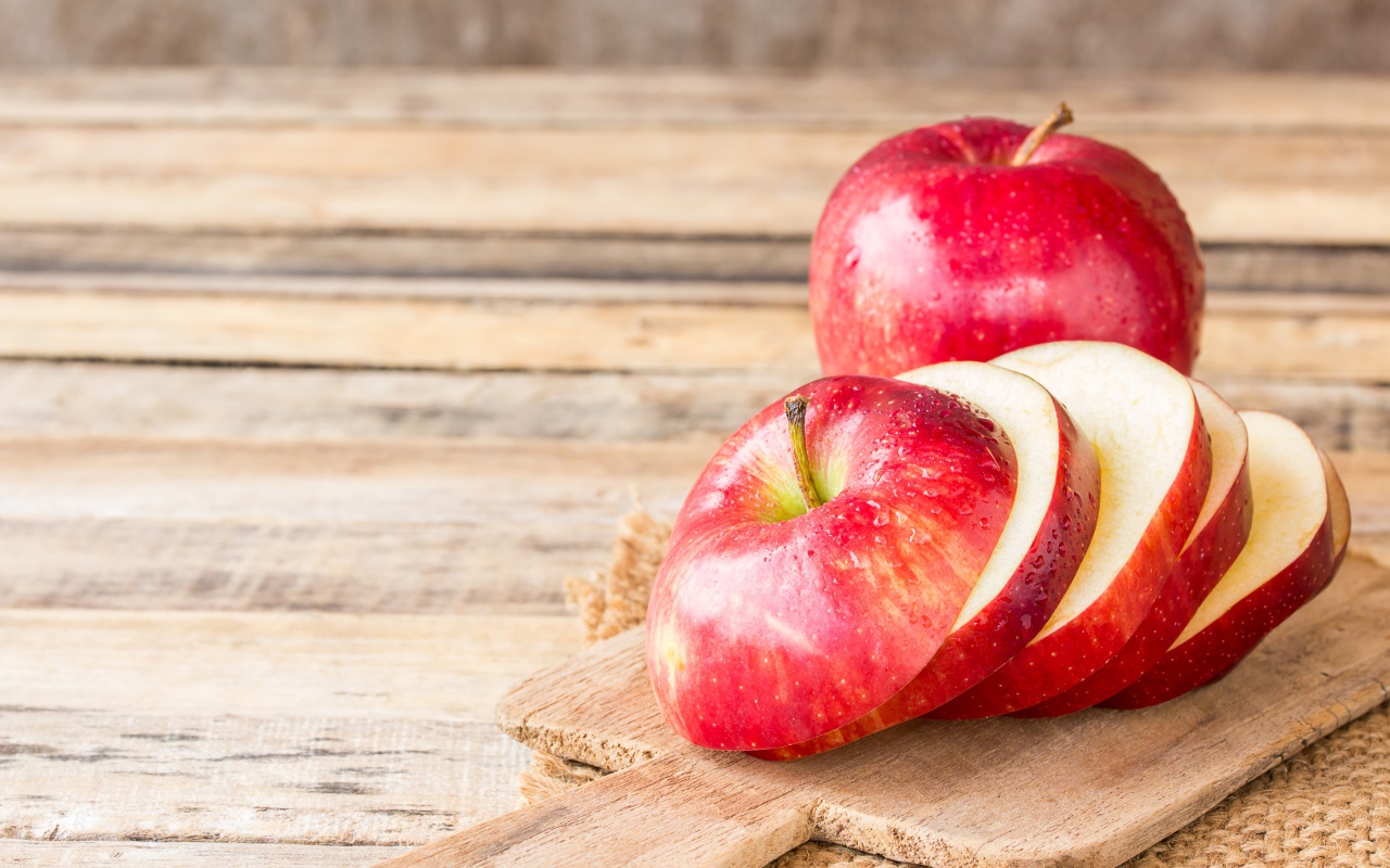 Нарезанное яблоко на разделочной доске 