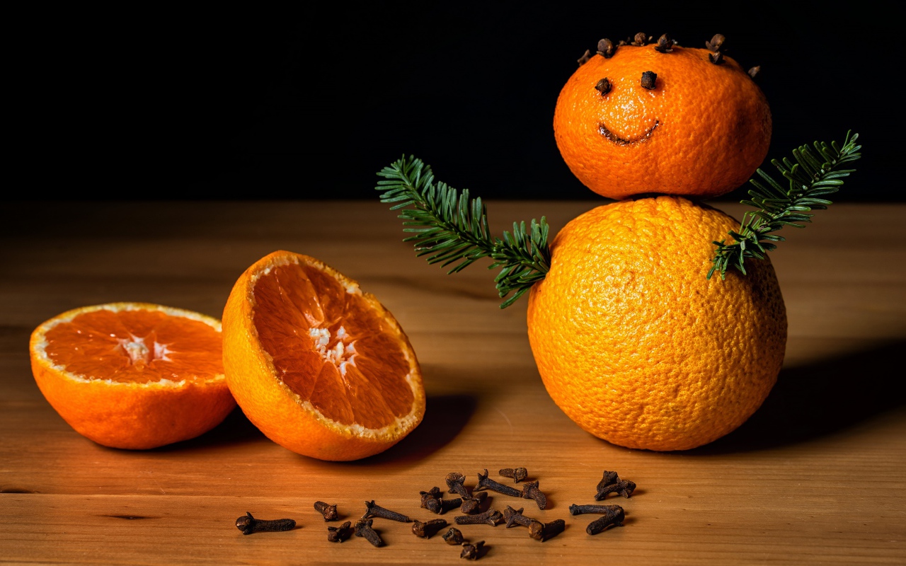 Снеговик из мандаринов и корицы на столе 