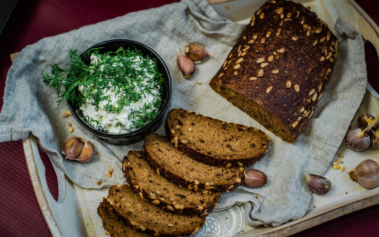 Свежий хлеб с зернами на столе с соусом и чесноком