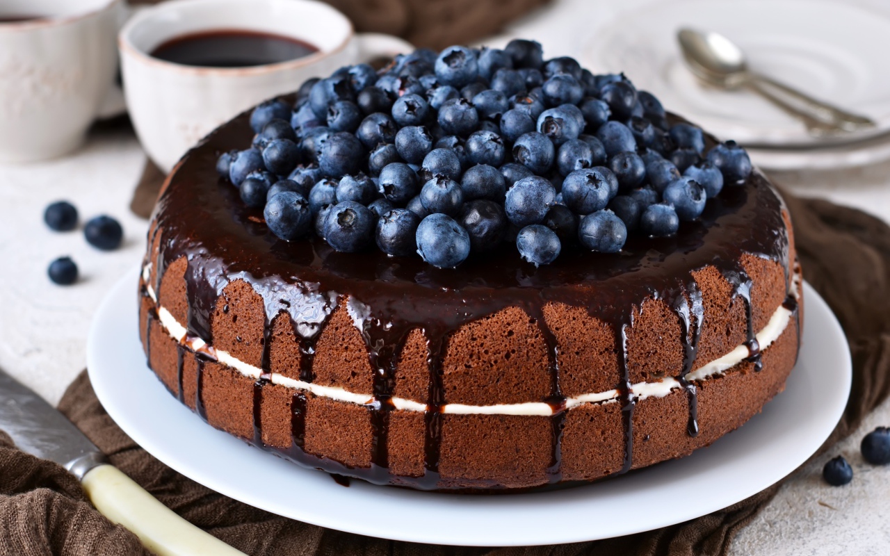 Шоколадный пирог с ягодами черники  на столе с кофе