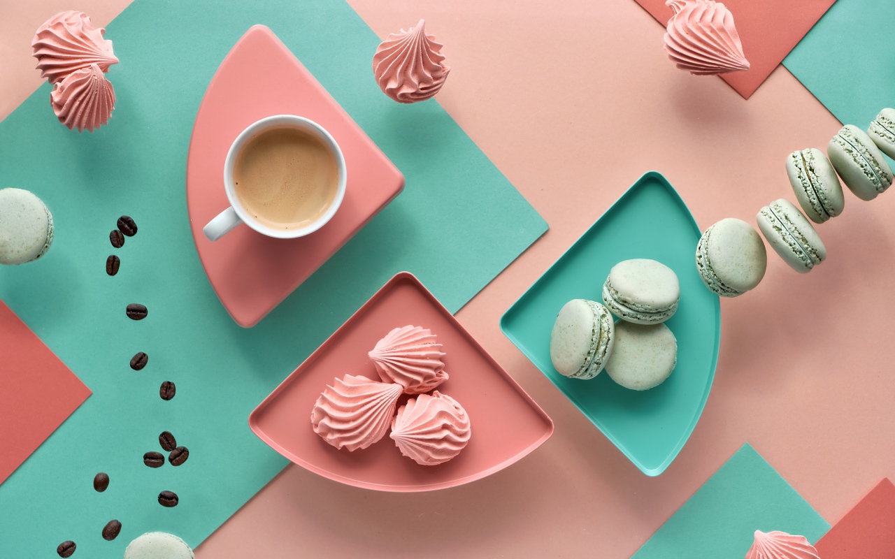 Чашка какао на столе с зефиром и десертом макарон 