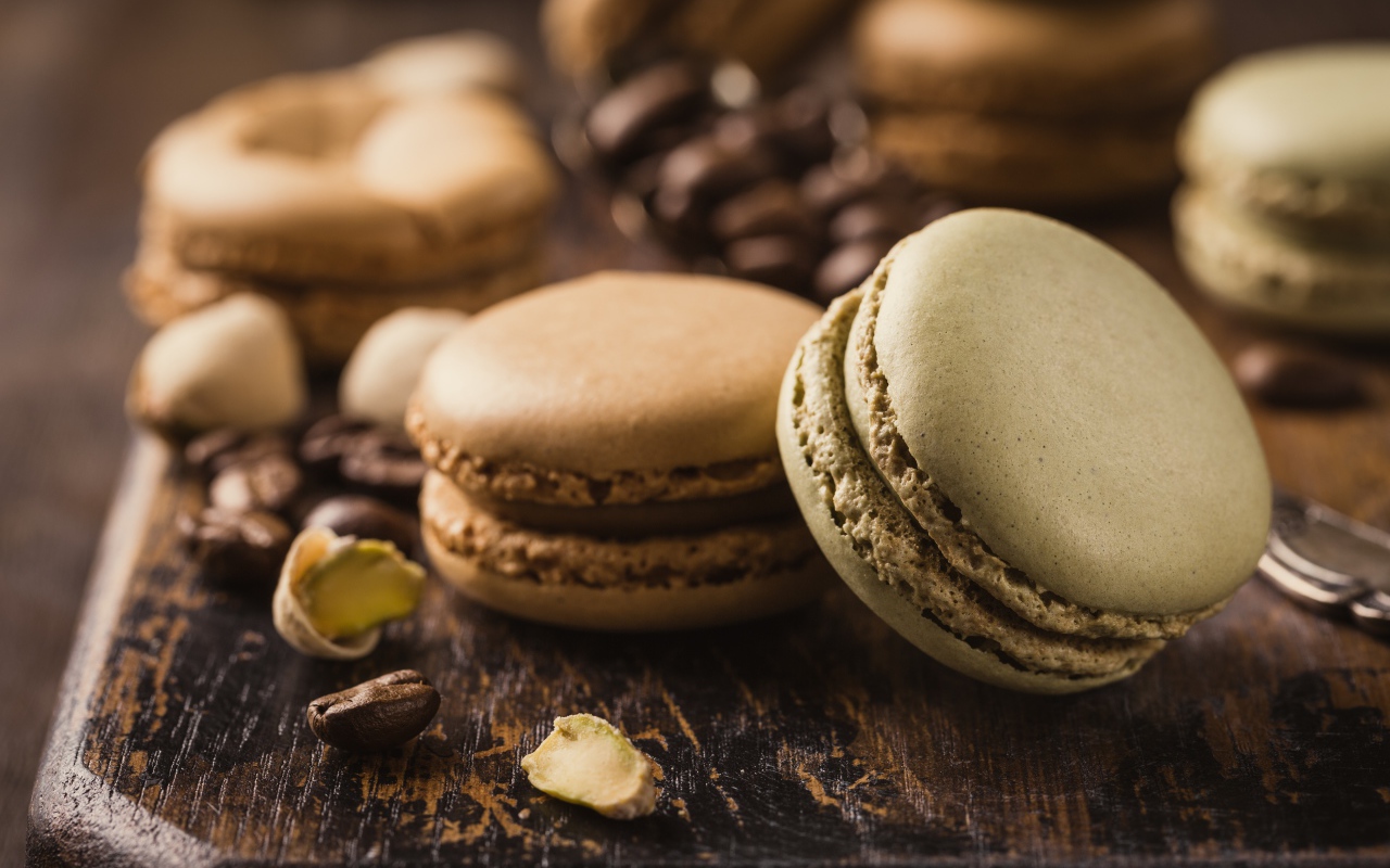 Десерт макарун на столе с кофейными зернами