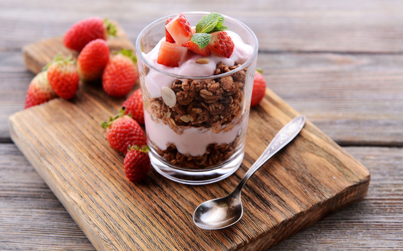 Овсяные хлопья в стакане с йогуртом и ягодами клубники