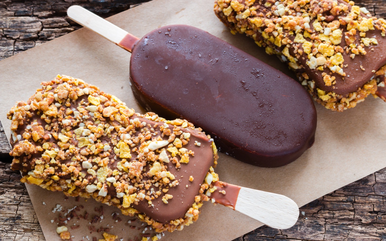 Вкусное холодное мороженое в шоколаде на столе 