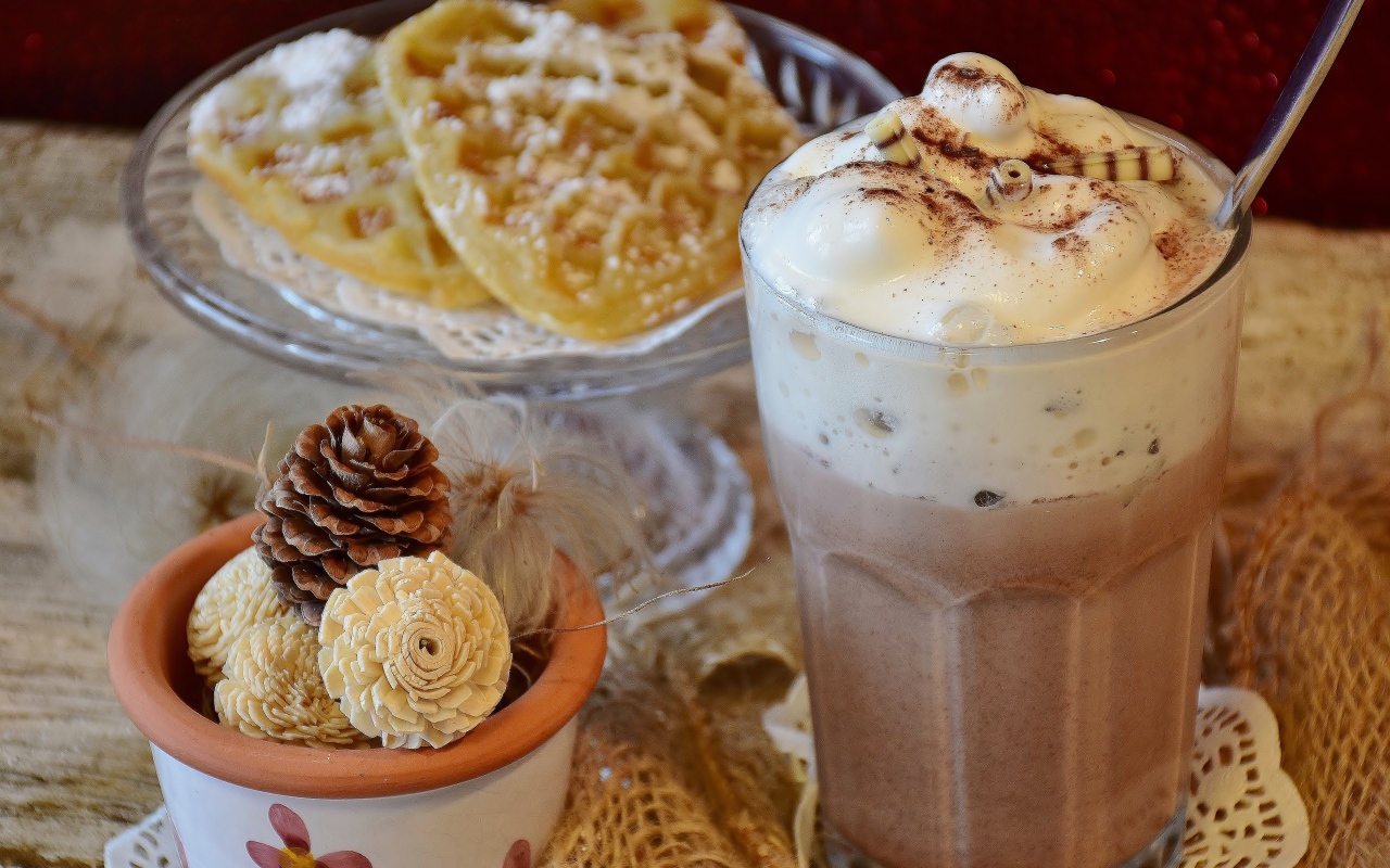 Горячий шоколад со сливками на столе с печеньем