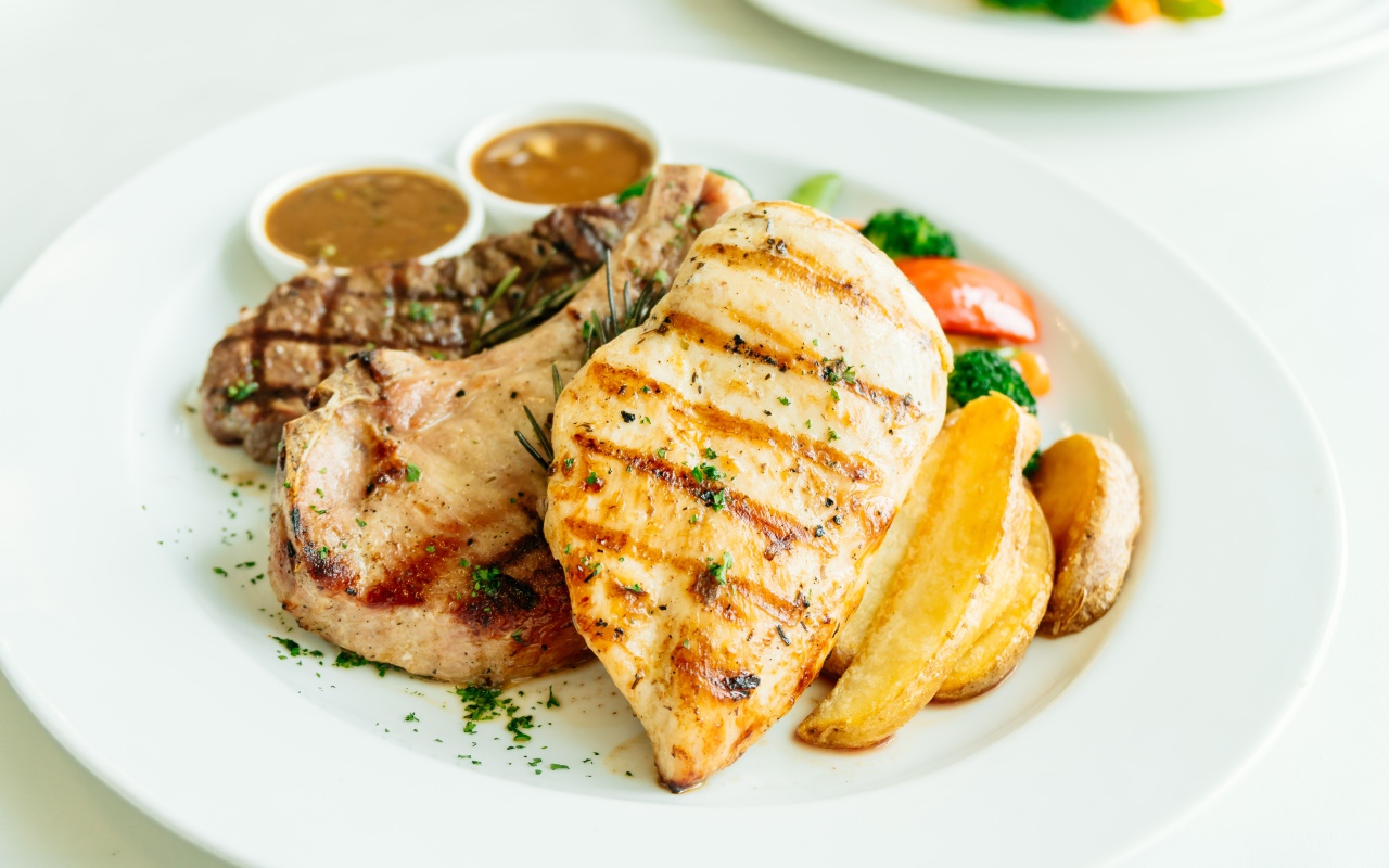 Запеченное мясо гриль на тарелке с овощами