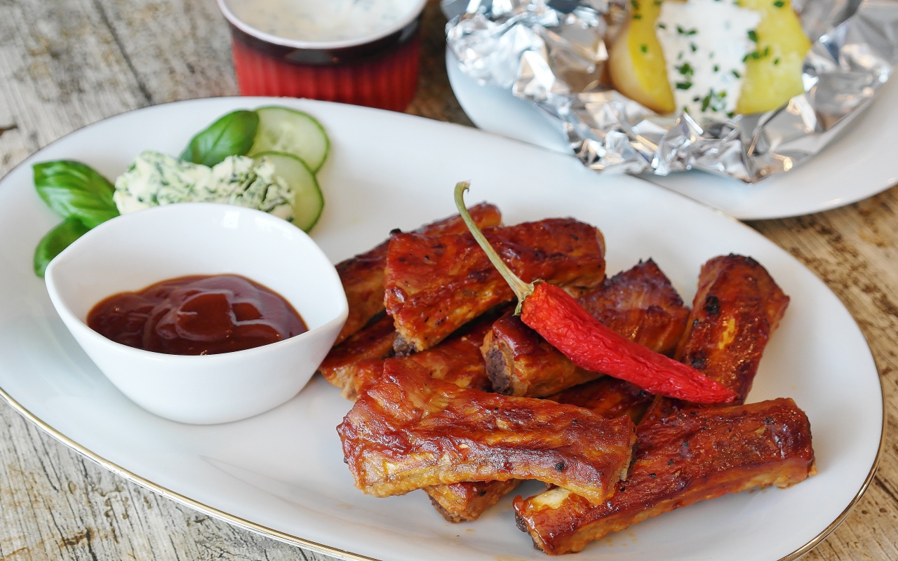 Ребрышки на тарелке с соусом и острым перцем