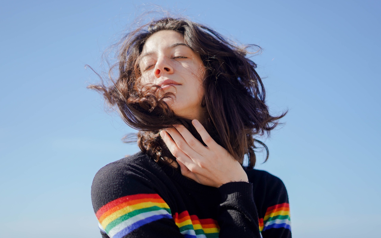 Молодая девушка греет лицо на солнце