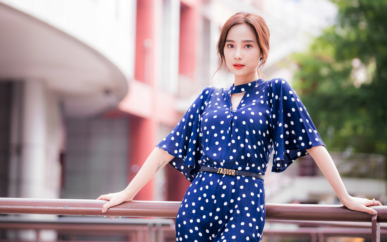 Девушка азиатка в синем платье в белый горошек