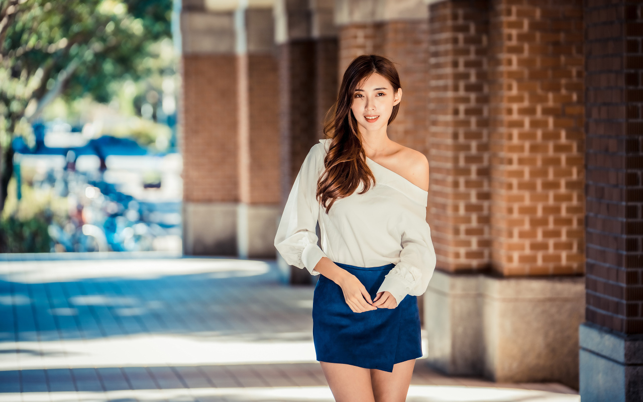 Девушка азиатка в короткой юбке у стены