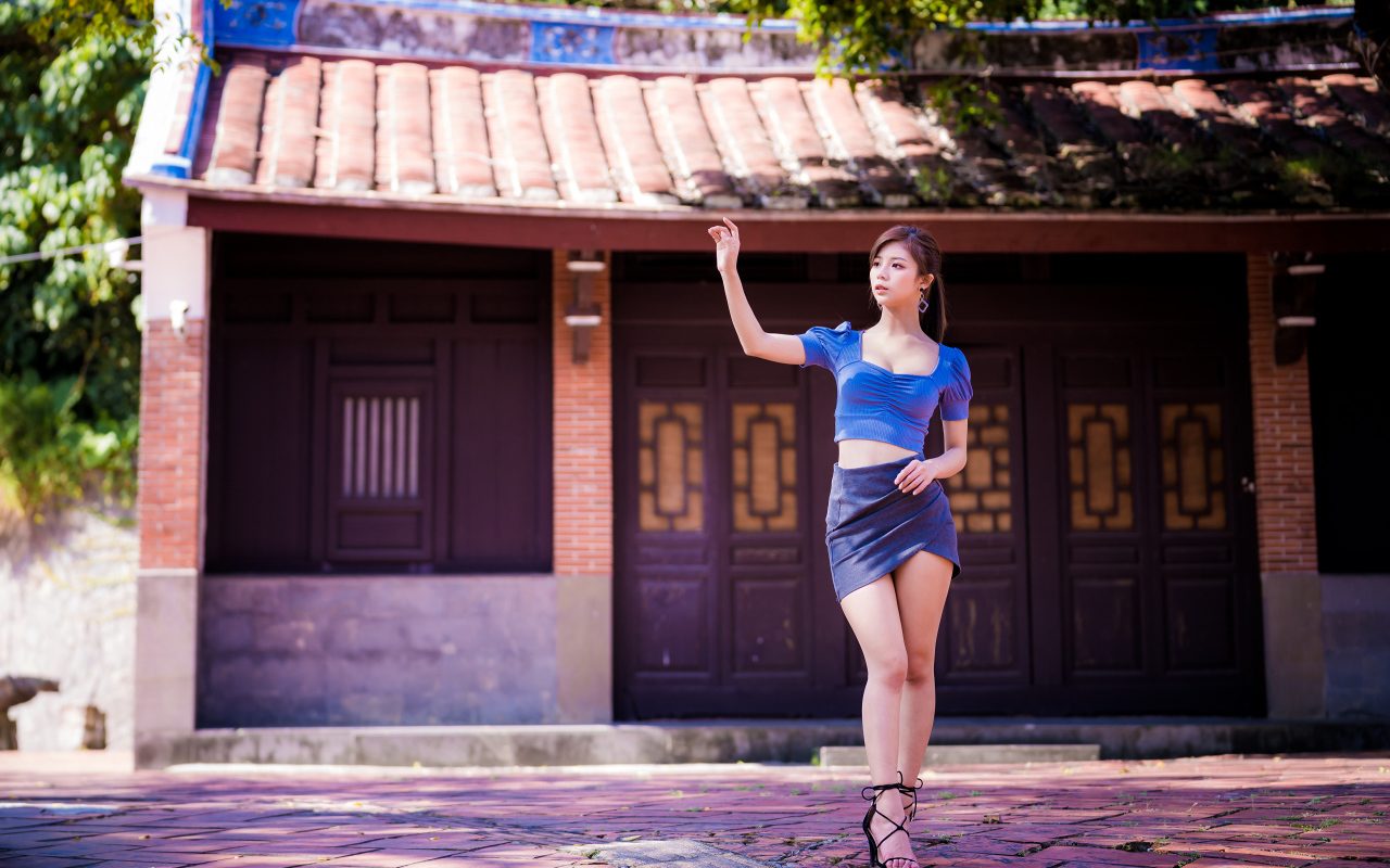 Девушка азиатка в короткой юбке у здания 