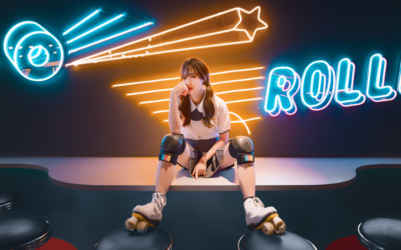 Девушка азиатка сидит в роликах на фоне вывески 