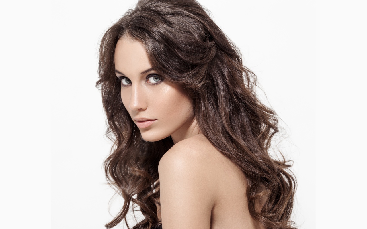 Красивая длинноволосая девушка шатенка на белом фоне 