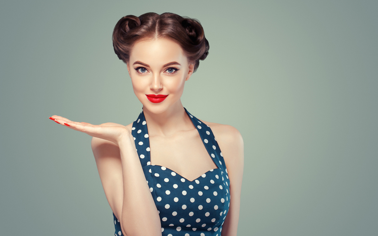 Красивая девушка в платье в горошек на сером фоне