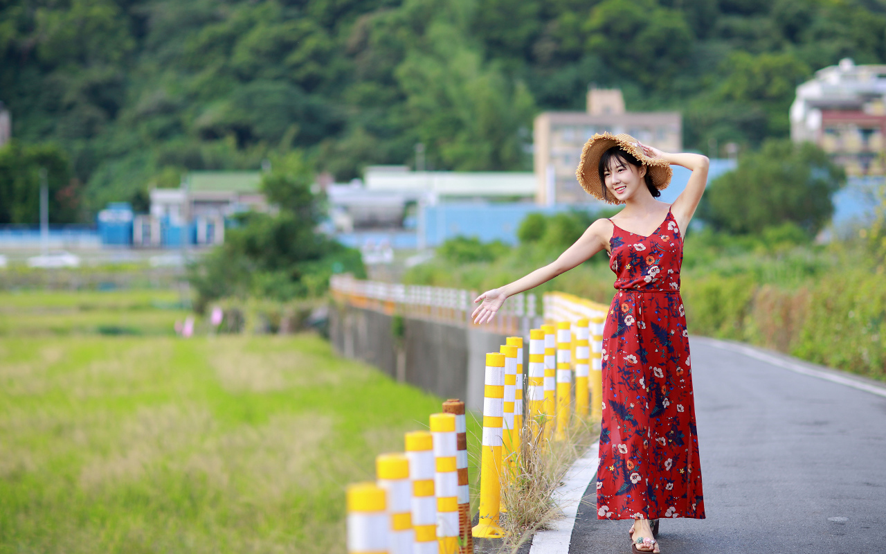 Веселая девушка азиатка в цветастом сарафане 