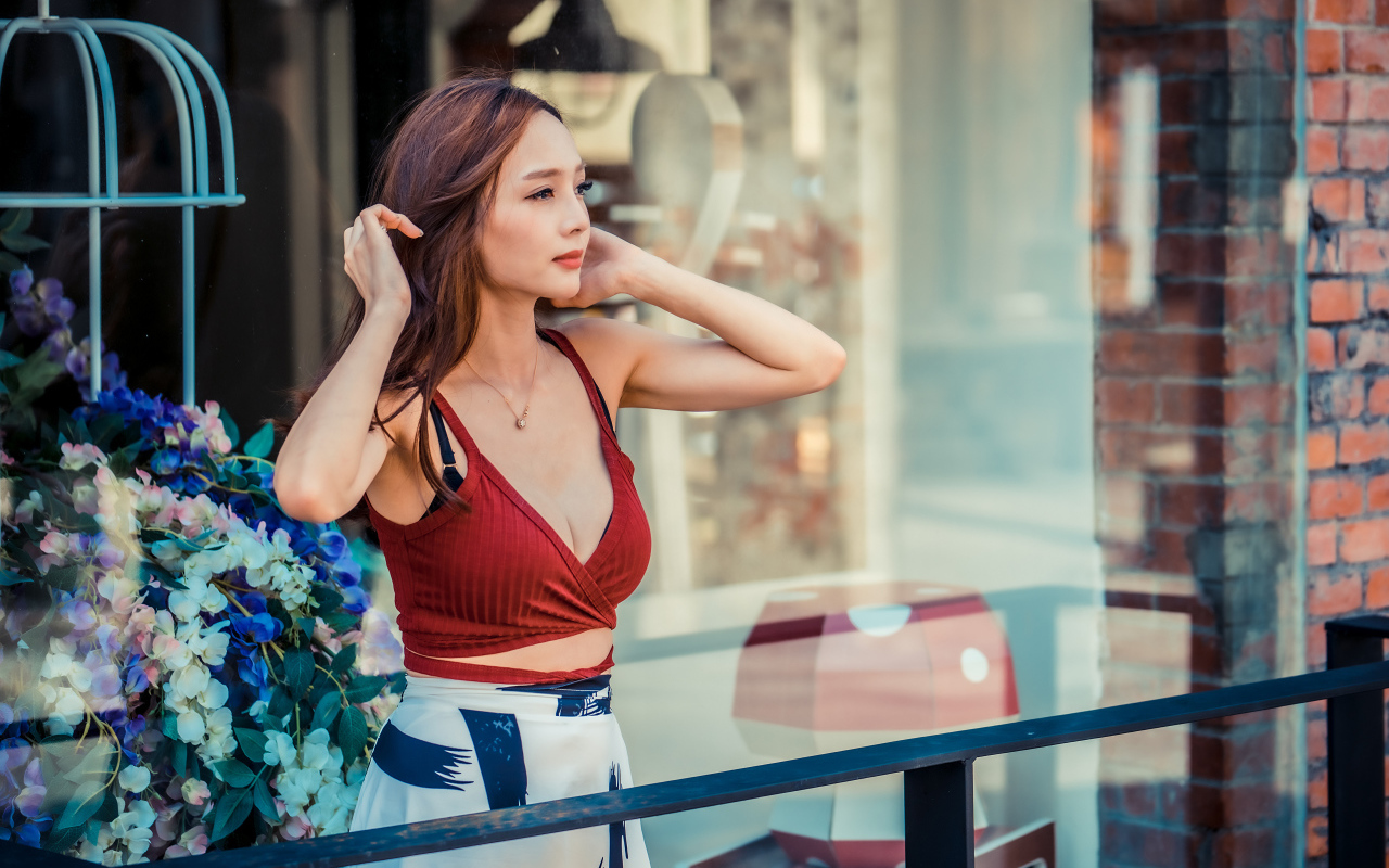 Нежная девушка азиатка стоит на балконе 