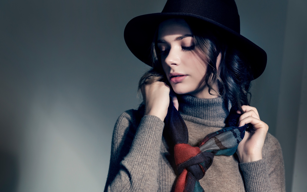 Девушка в сером свитере с платком на шее в черной шляпе