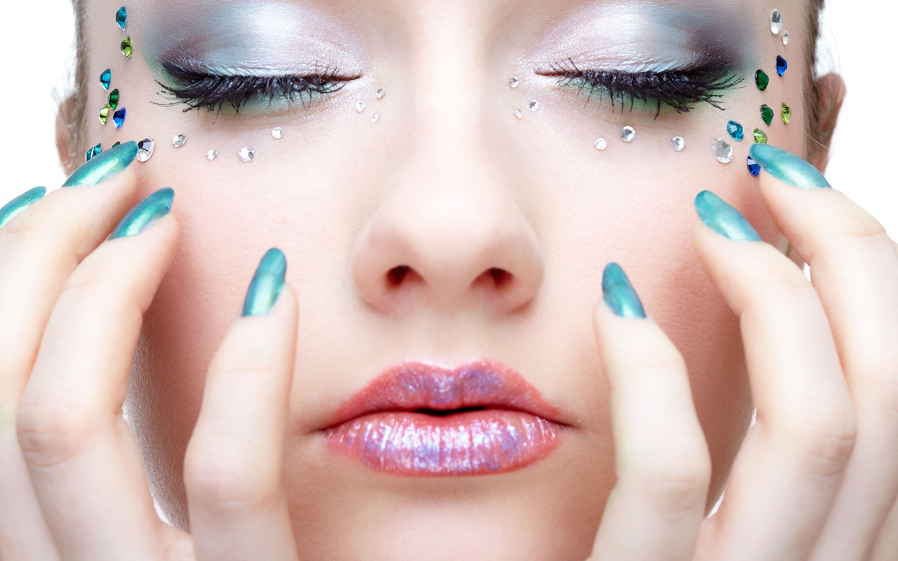 Девушка  с ярким макияжем и стразами на лице 