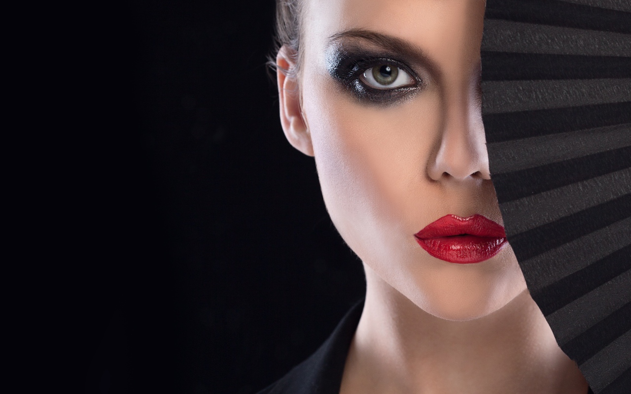 Девушка с макияжем закрывает лицо веером