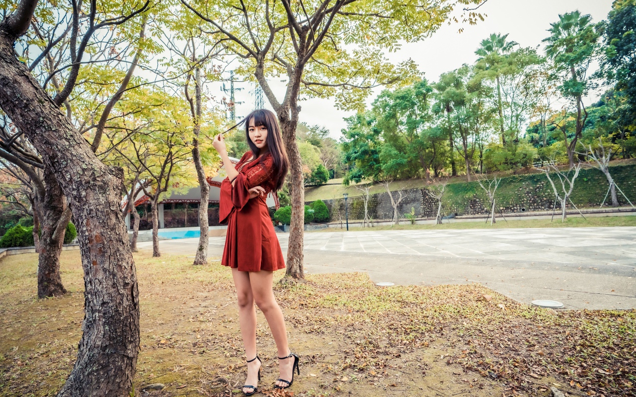 Длинноногая девушка азиатка в коротком красном платье 