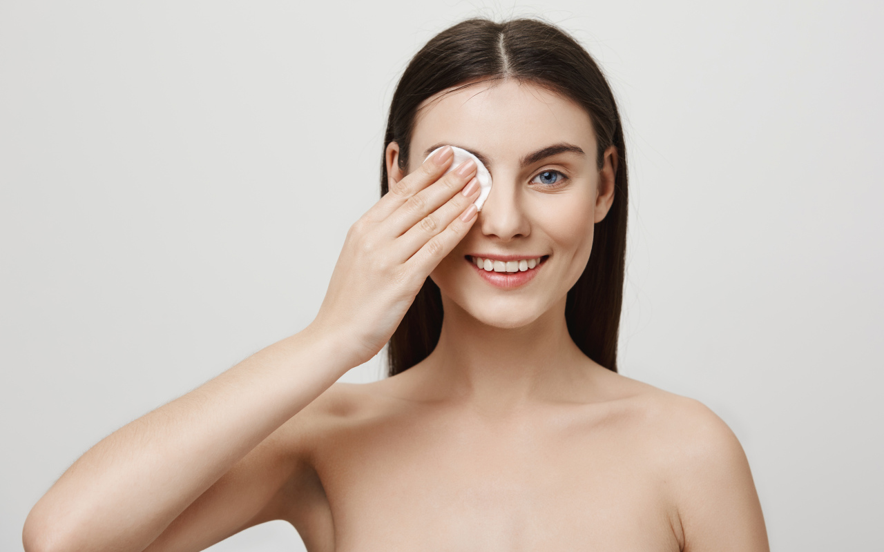 Настоящая голубоглазая девушка снимает макияж с лица