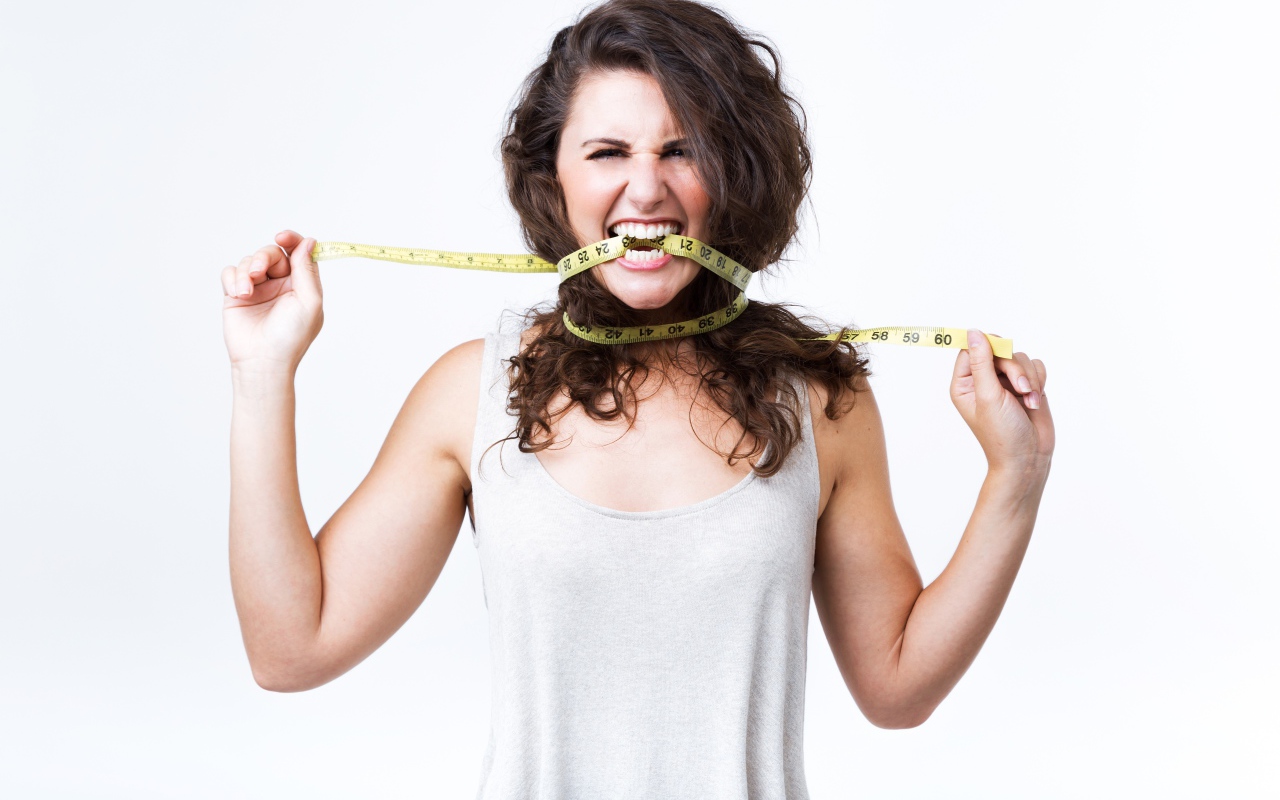 Блондинка в белой майке грызет сантиметр 