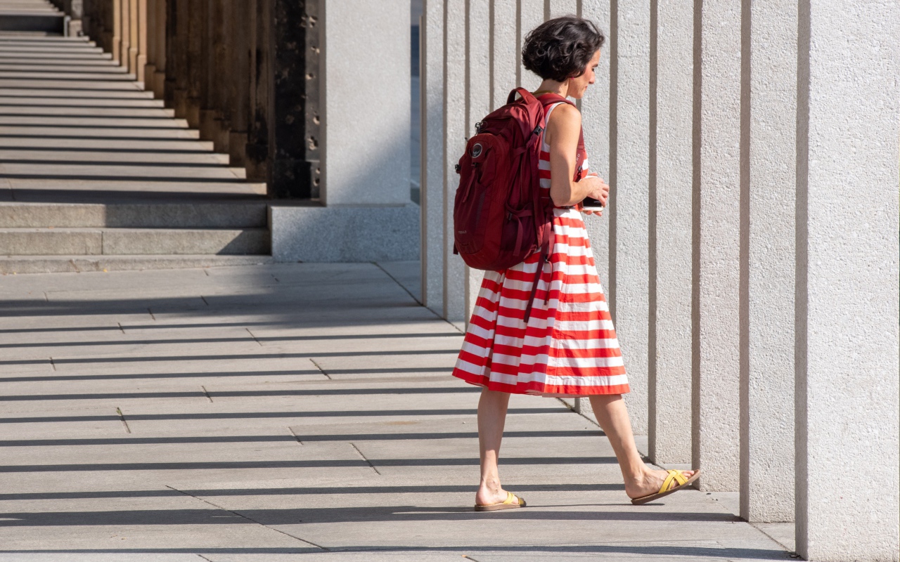 Женщина в красном полосатом платье с рюкзаком