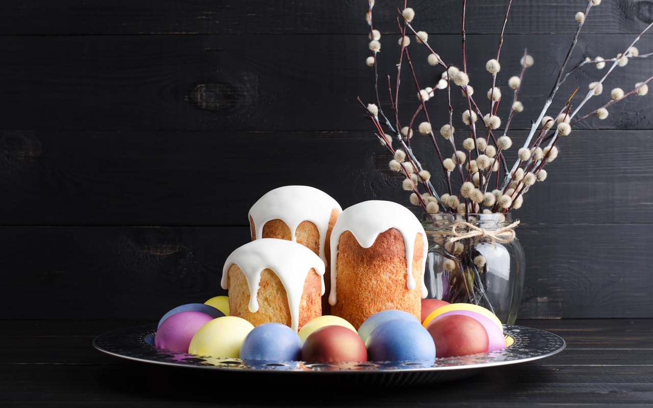 Вкусные куличи на подносе с яйцами и ветками вербы на Пасху