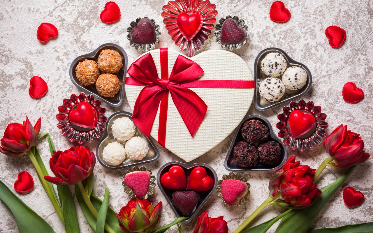 Конфеты и подарок на столе с букетом тюльпанов для любимой на 14 февраля