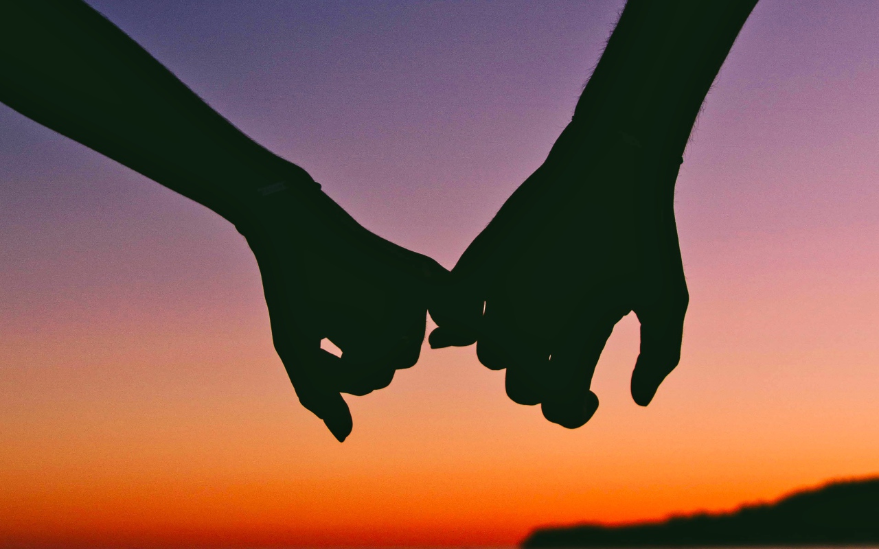Hands of a couple in love at sunset