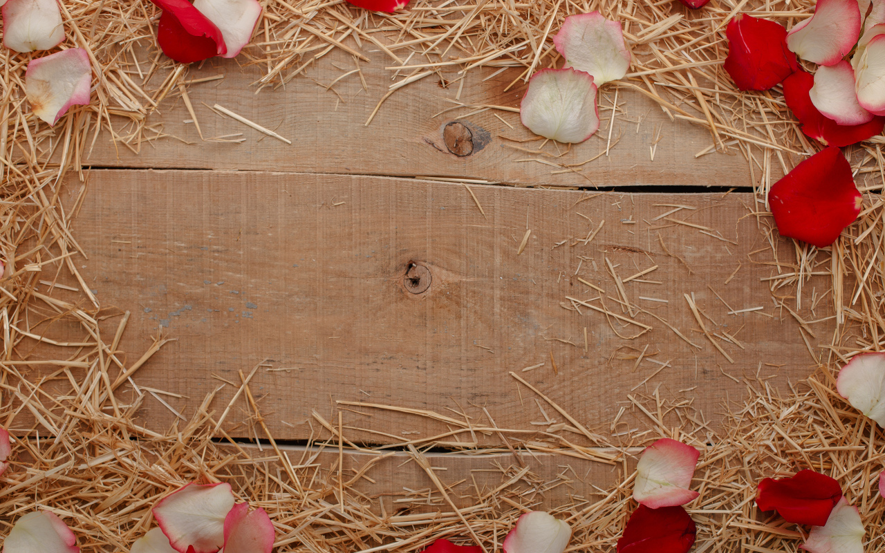 Сено и лепестки роз на деревянном столе 