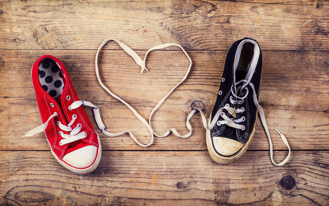 Сердце из шнурков кед на деревянном столе 