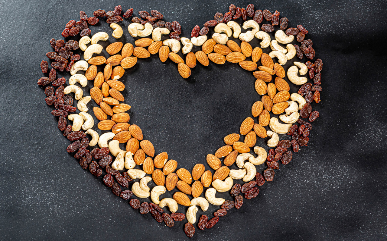 Heart made of nuts and raisins on a gray background