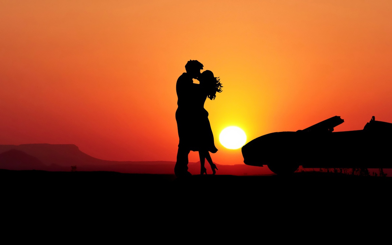 Целующаяся пара на фоне заката с автомобилем