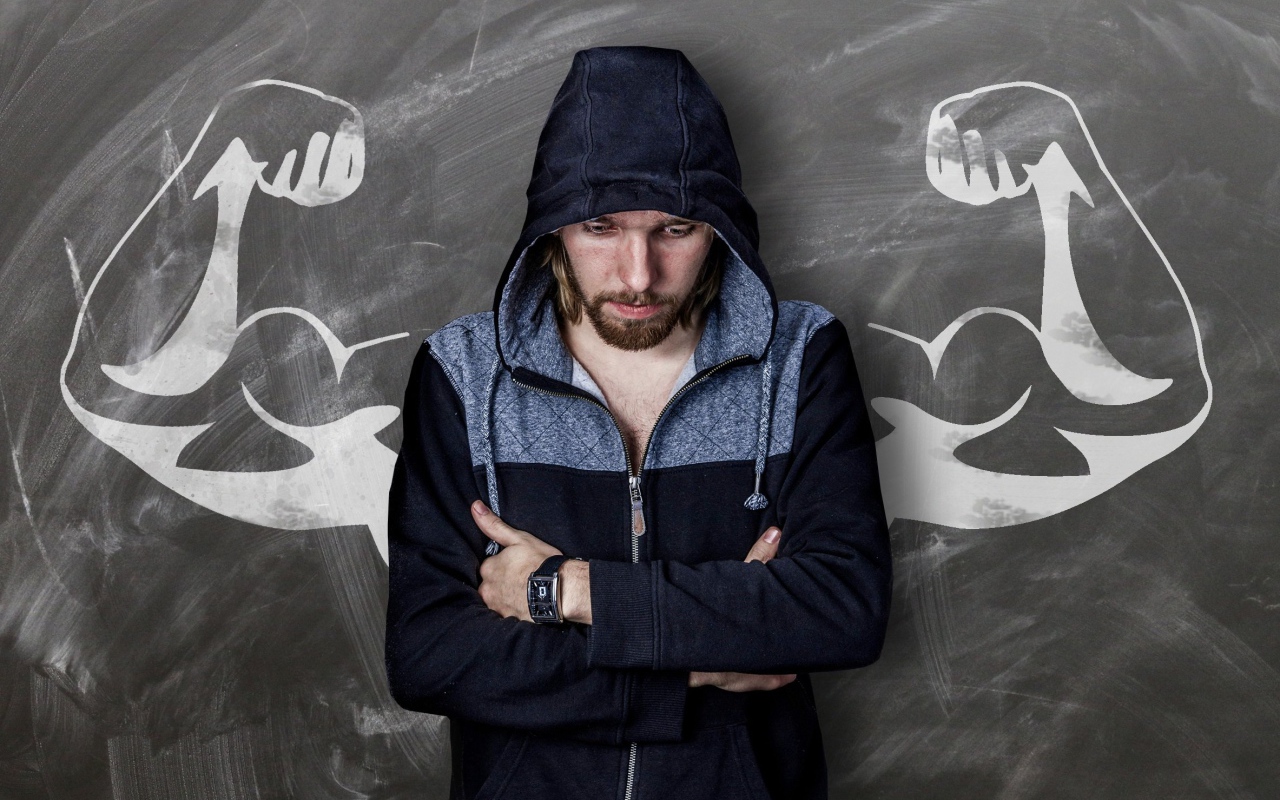 Мужчина с часами на руке грустит у стены