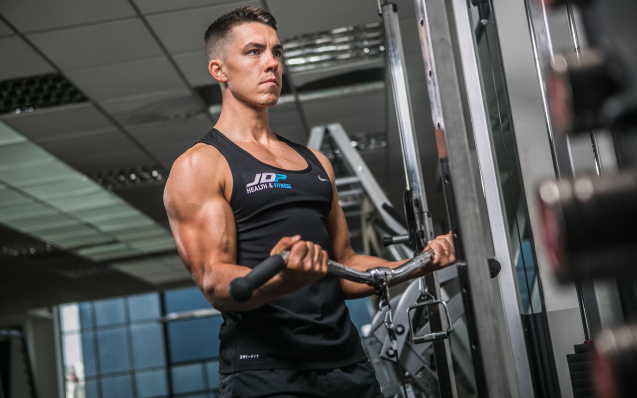 Накаченный мужчина занимается на тренажере в спортзале