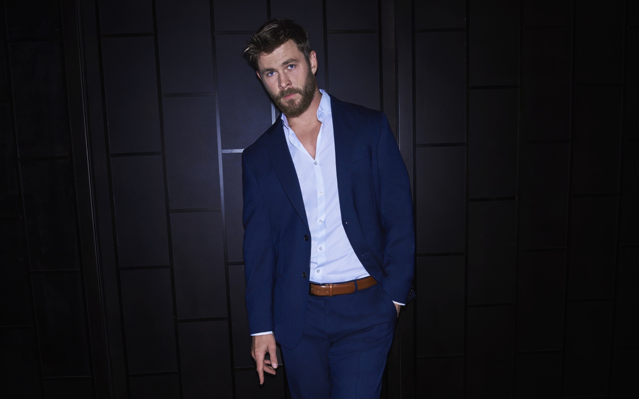 Австралийский актер Крис Хемсворт в костюме у стены