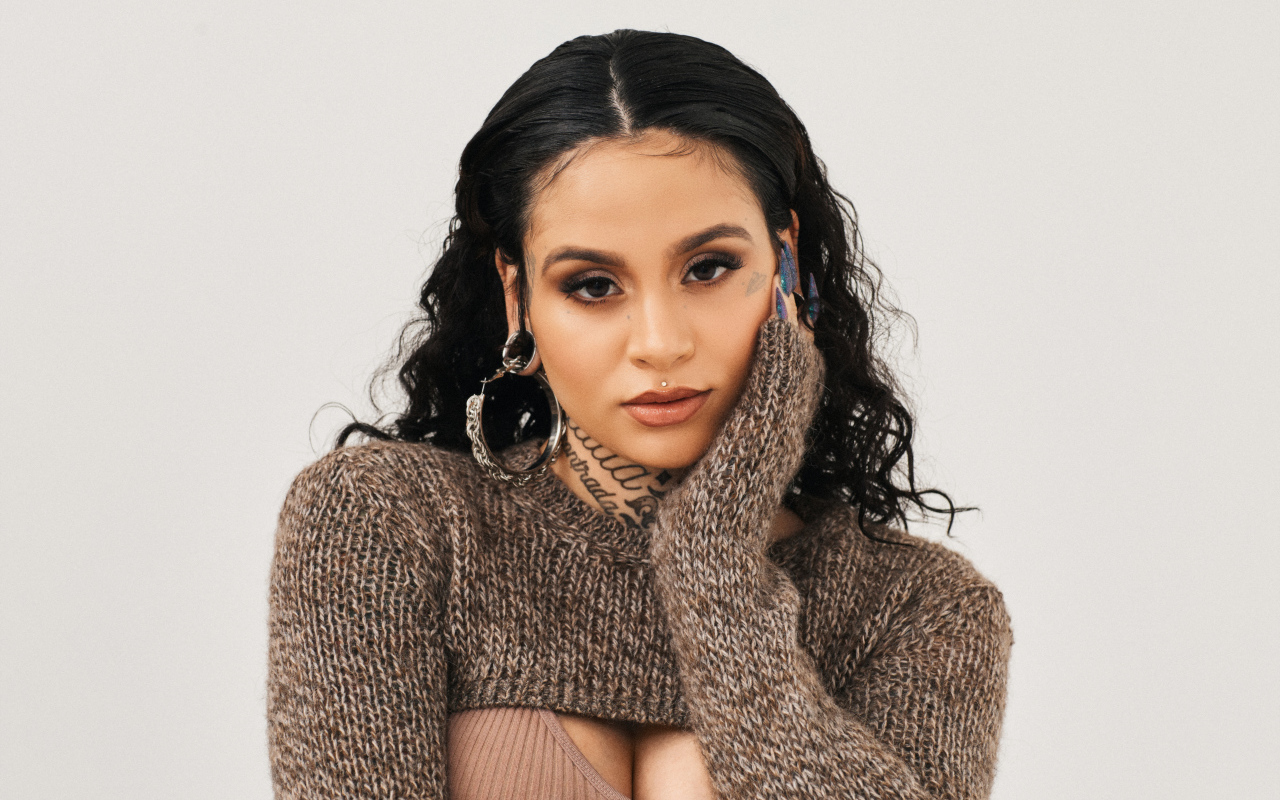 Американская певица Кейлани в свитере на сером фоне