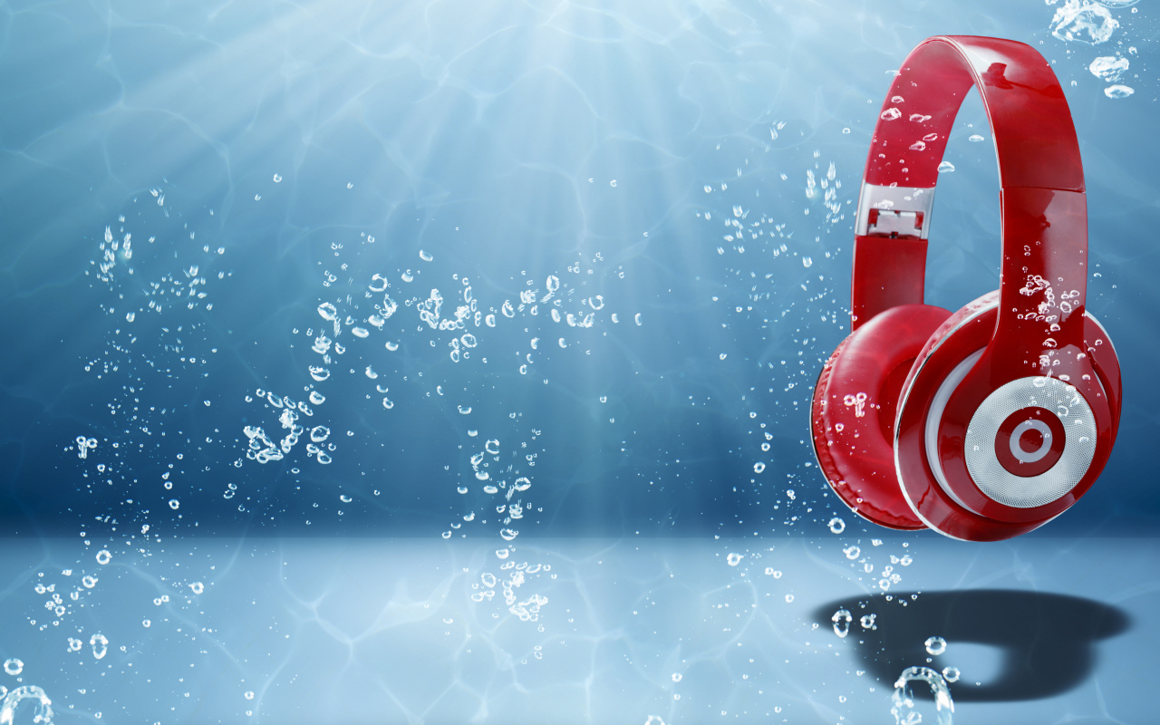 Большие красные наушники под водой на голубом фоне