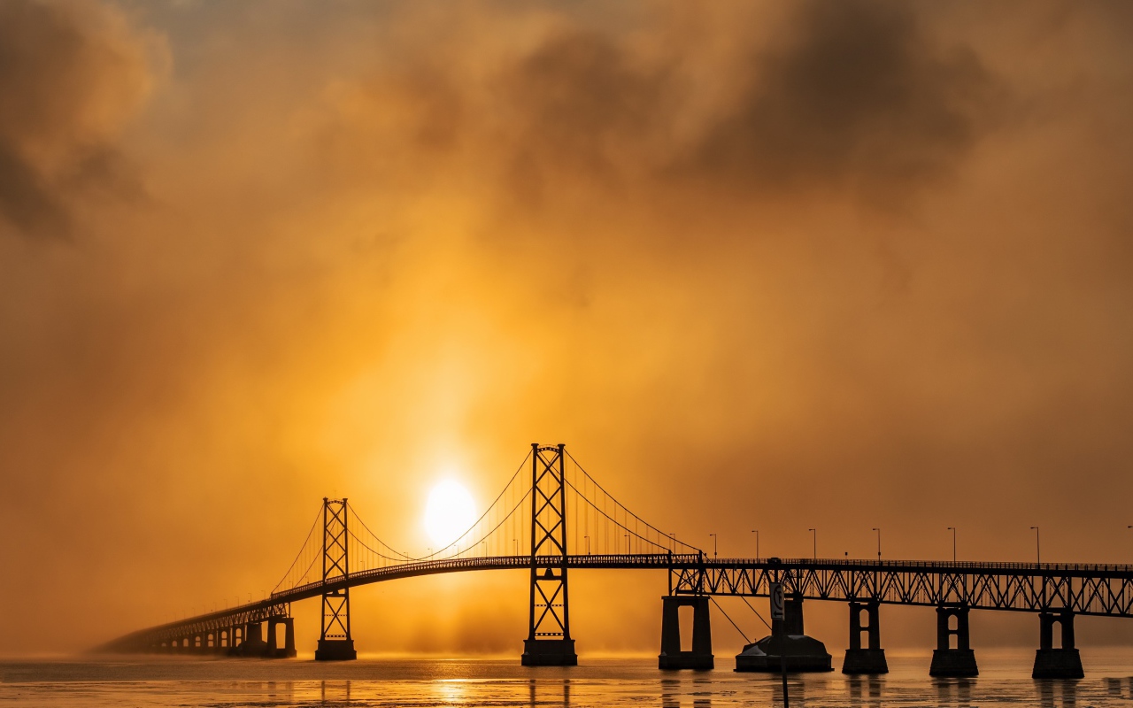 Мост через реку в тумане на восходе солнца