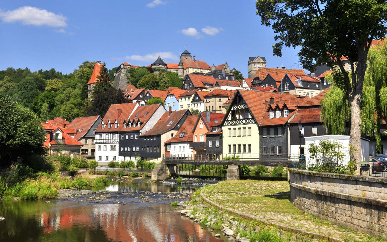 Много домов у пруда на фоне голубого неба