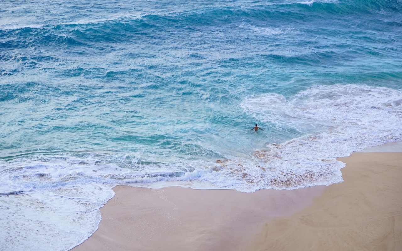 Голубая вода океана на пляже с желтым песком